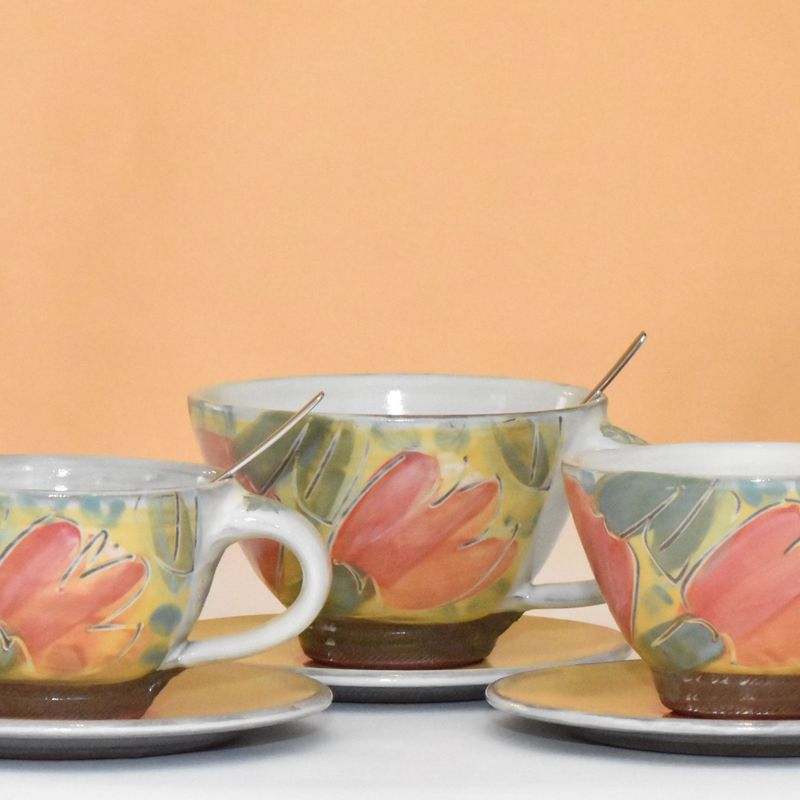 Drei bauchige handgetöpferte Keramiktassen mit Unterteller nebeneinander.